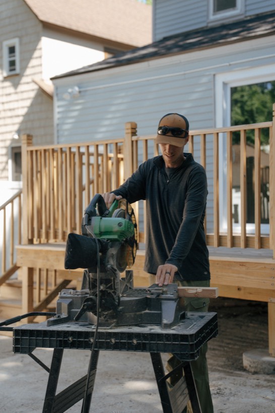 Dave Arthur cutting boards on a miter saw at a deck build